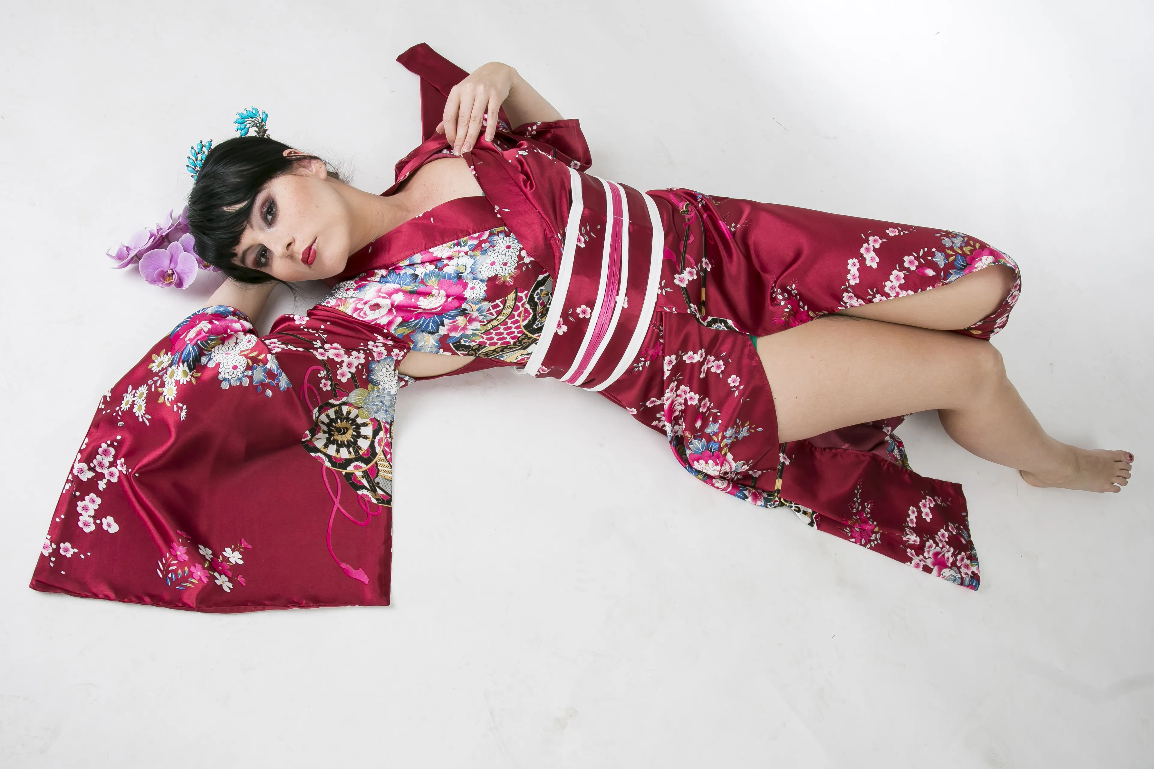 Auf dem Bild liegt eine weibliches Model auf dem Boden bekleidet mit einem Kimono ähnlichen Morgenmantal mit den Haaren auf Geishaart gesteckt